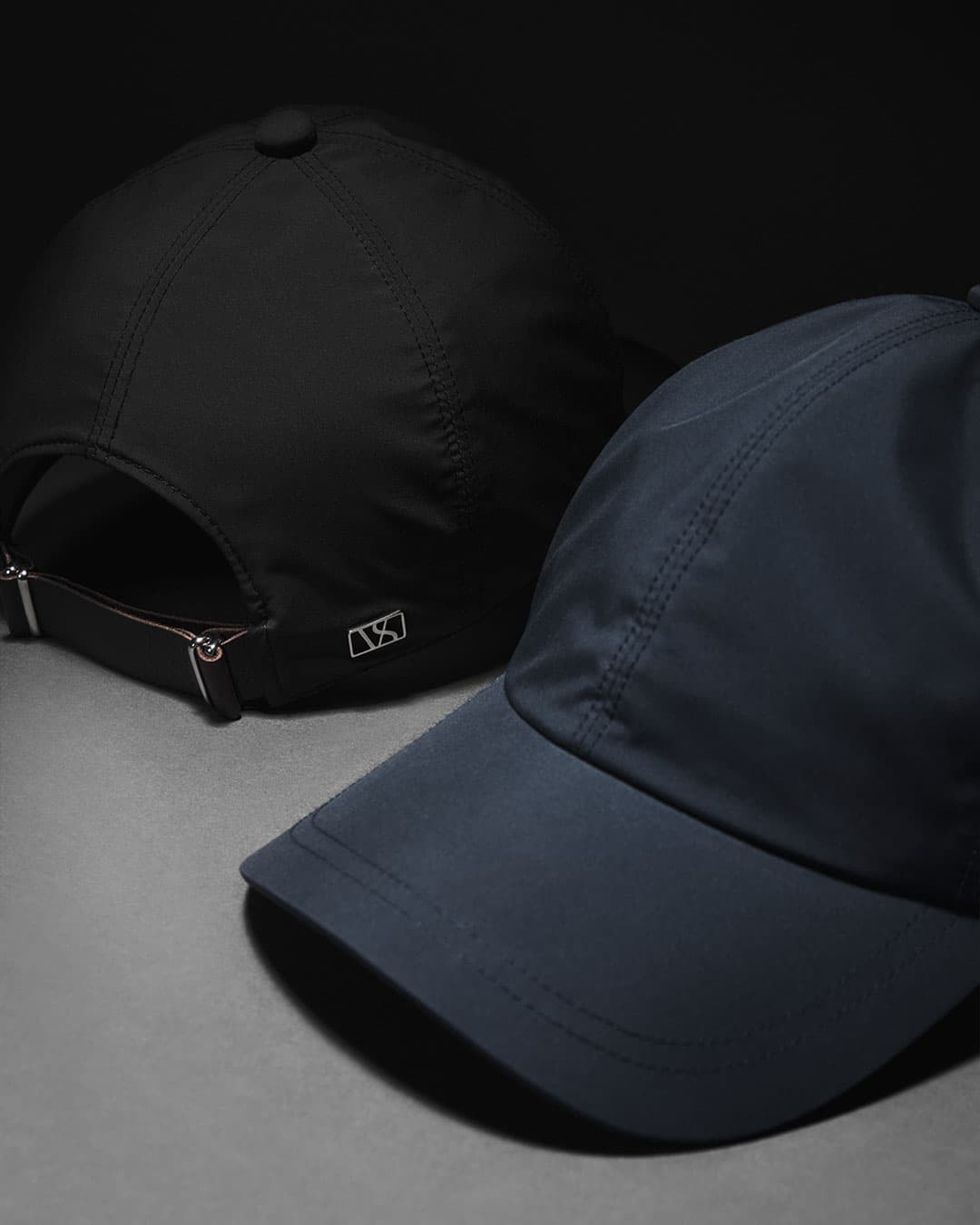 Front and back view of legacy soft microfiber caps from varsity headwear in black and navy
