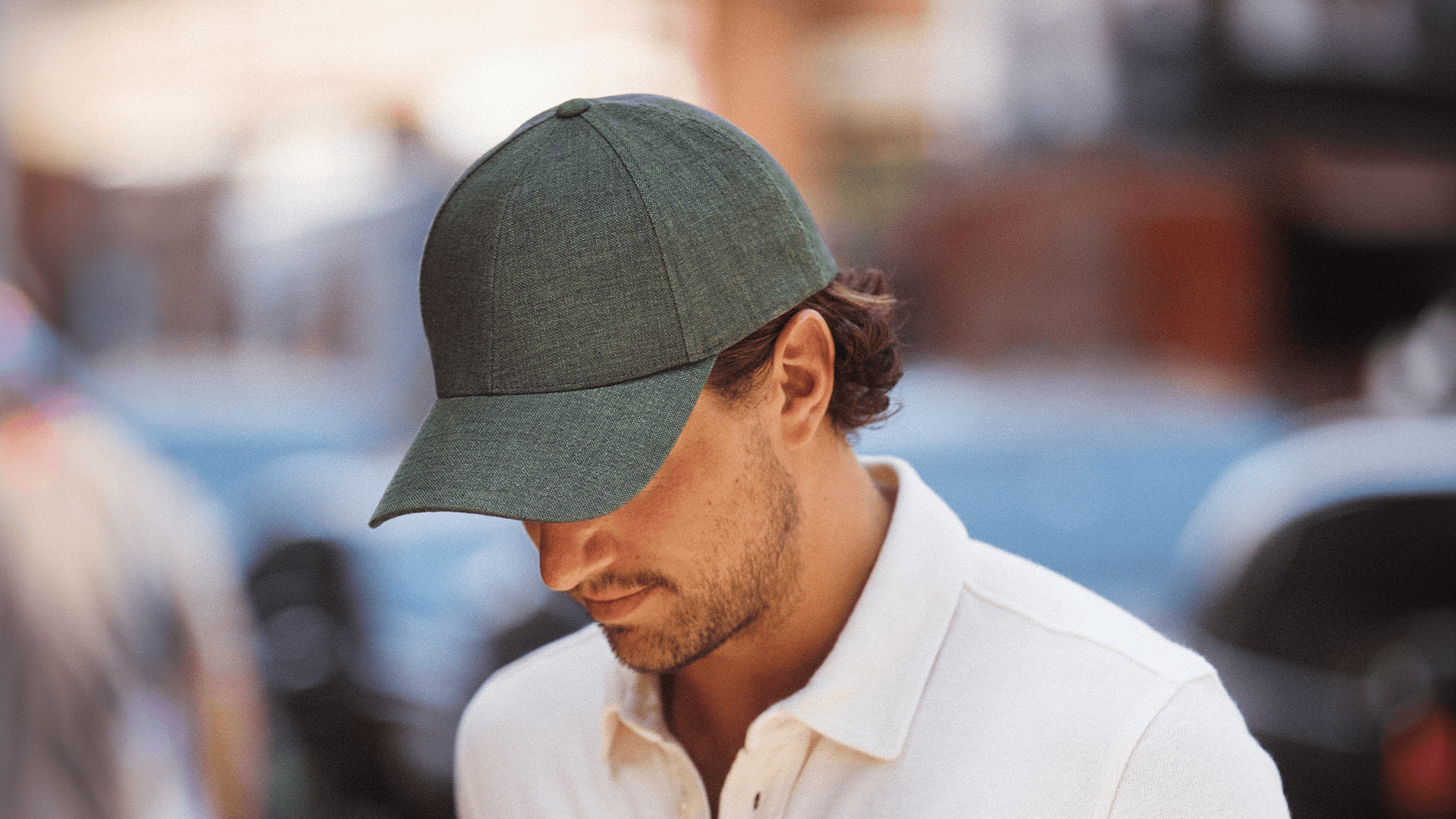Side view of a male wearing a legacy structured french olive linen cap from varsity headwear