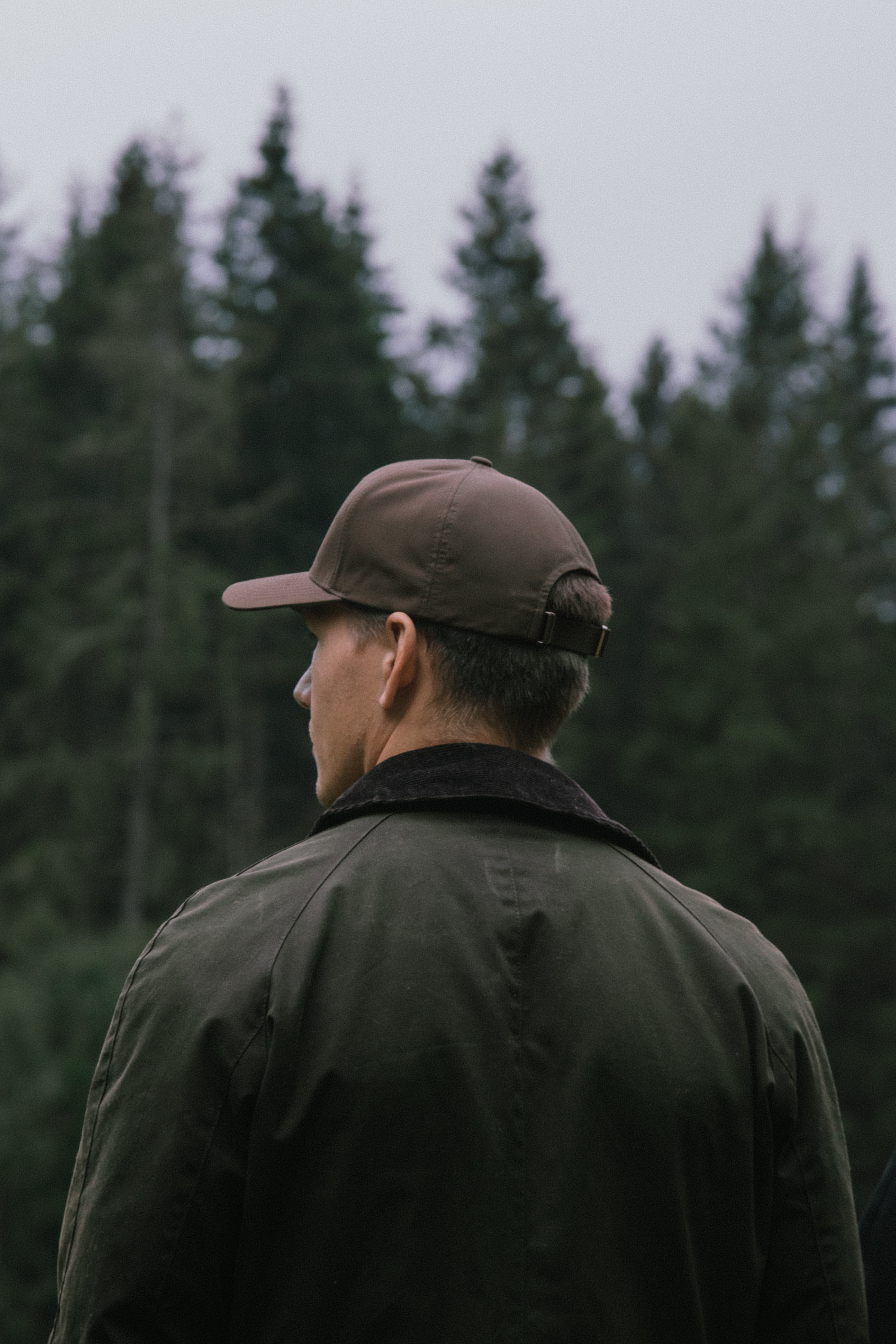Back view of male wearing a brown cruz cap from Varsity Headwear in the woods