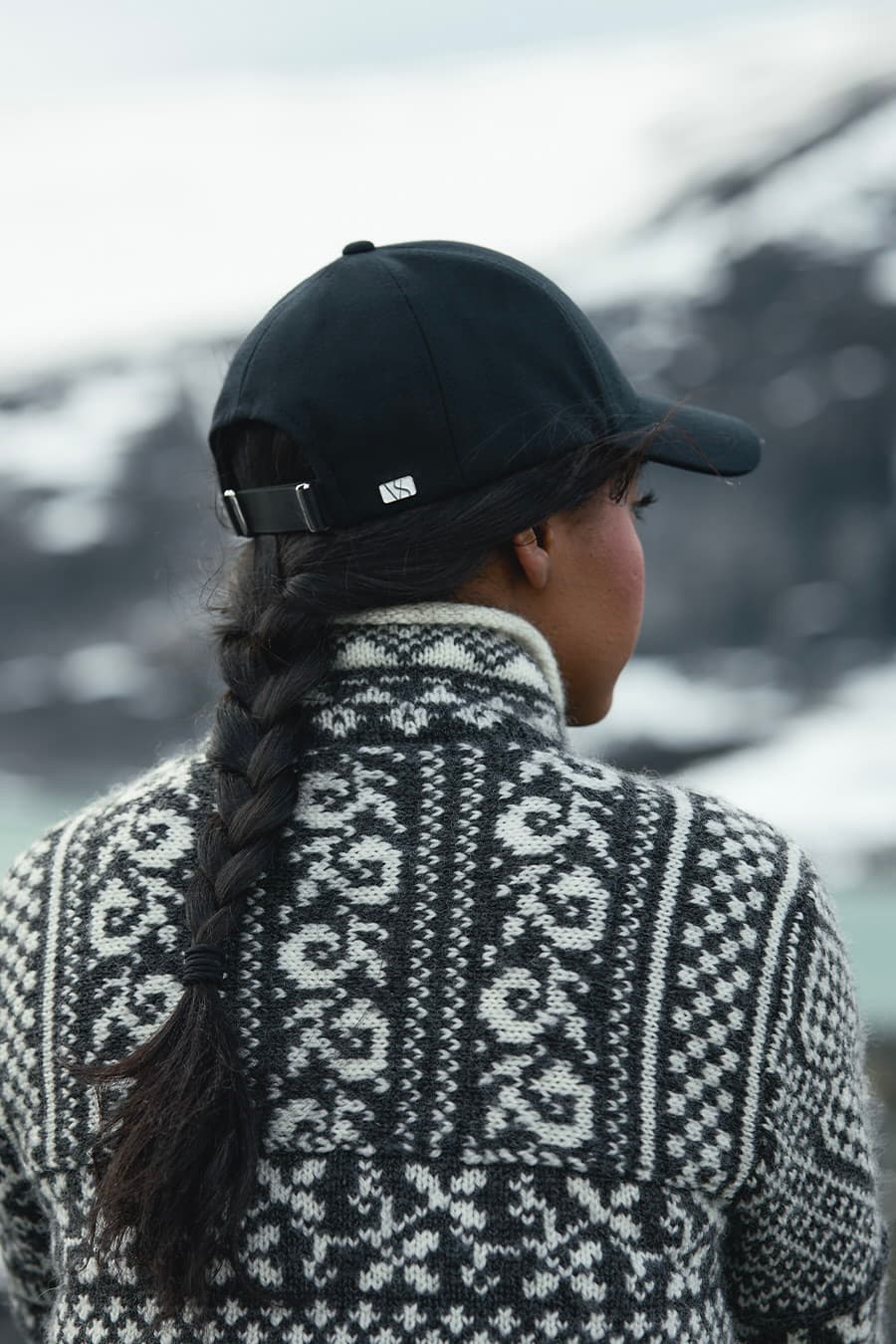 Back view of a black merino wool cap from varsity headwear in Nordic landscape